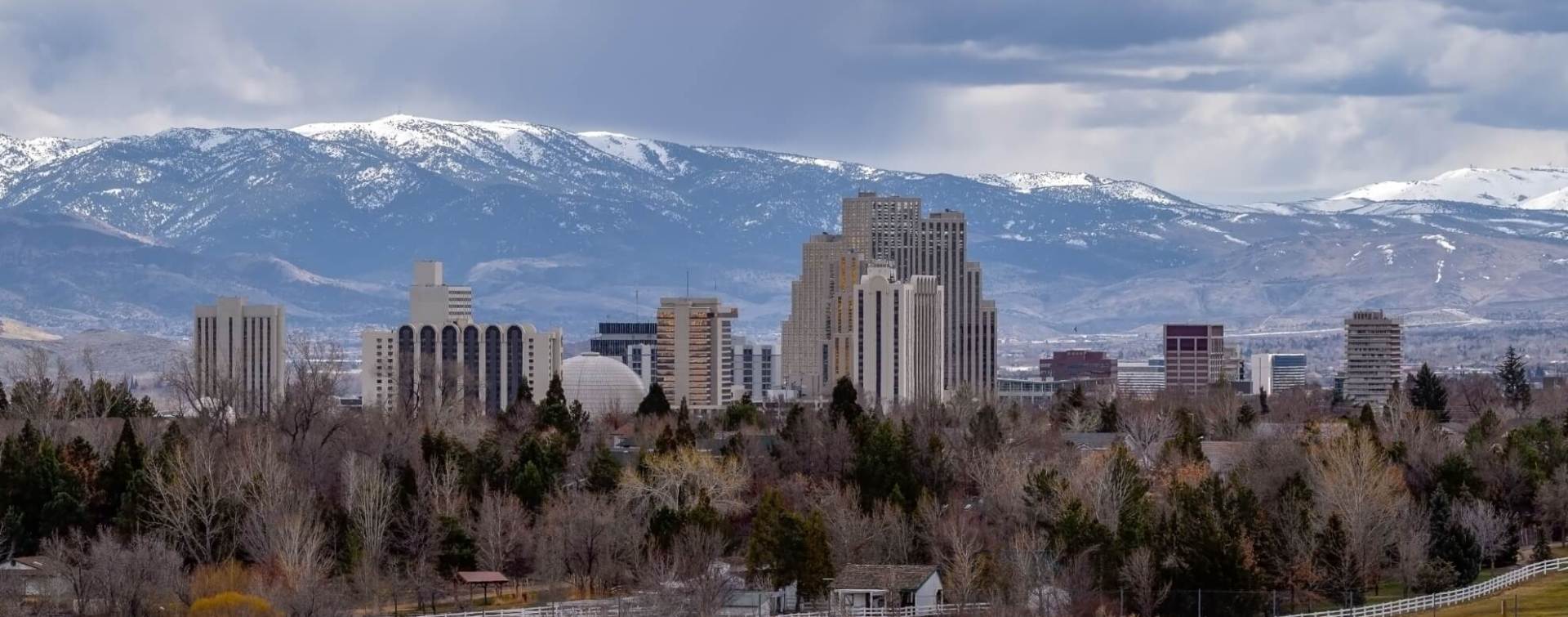 landscape view of the Reno central business district with snowcapped mountains in the distance beyond