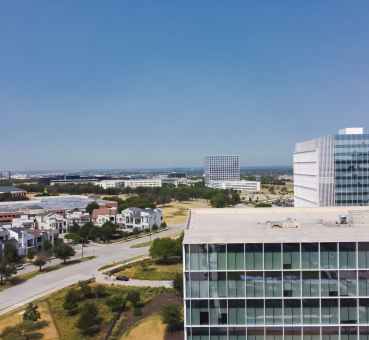 panoramic view of Plano office space buildings in the foreground and nearby residential villas in the background