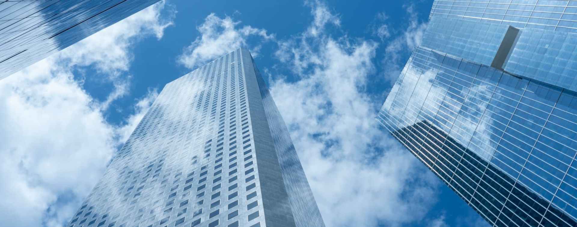 vertical view of modern office buildings facing up from the ground level